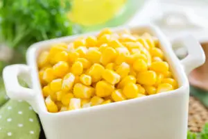 corn in a white dish sitting on a table