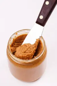 Peanut butter bottle with knife on the table