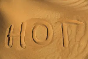 The word hot written on the sand in desert